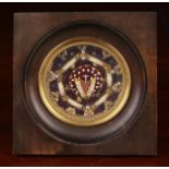 A Small Framed Collection of Relics encased in a glazed crimson velvet lined roundel.