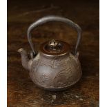 A Small Cast Iron Tetsubin Teapot with swing handle,
