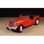 A Red Fibreglass Treadle-Action Toy Morgan +8 Sports Car with metal chassis, solid rubber tyres,