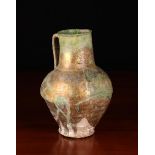 An Ancient Persian Ceramic Jug (A/F) with thick dripped iridescent gold/green glaze,