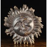 An 18th Century Double-sided Carved Wooden Sunburst Facemask; probably a pub sign,