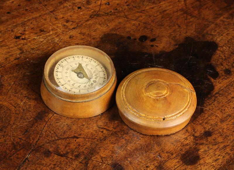 A Small Pocket Compass in a 19th Century Turned Wooden Case, 1¾" (4.5 cm) in diameter.