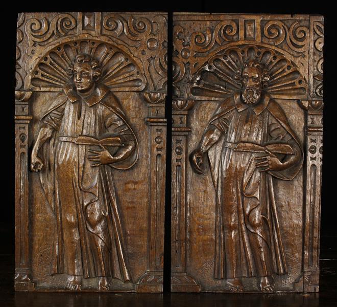 A Pair of 17th Century Oak Panels relief carved with Saints stood within arches and enriched with