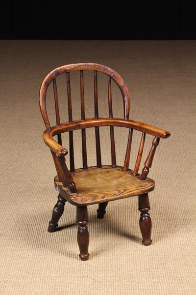 A 19th Century Child's Yew-wood Hoop Back Windsor Armchair with elm seat on baluster legs (feet cut