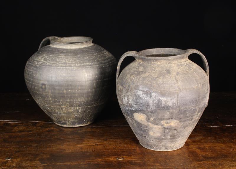 Two Antique Hand-Thrown Bulbous Black Pigment Clay Pots: One with a single strap handle from the