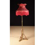 An Arts & Crafts Brass & Copper Telescopic Standard Lamp with a fringed crimson silk shade