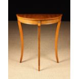 A Small Demi-lune Side Table with burr-yew veneered top on square sabre legs headed with brass