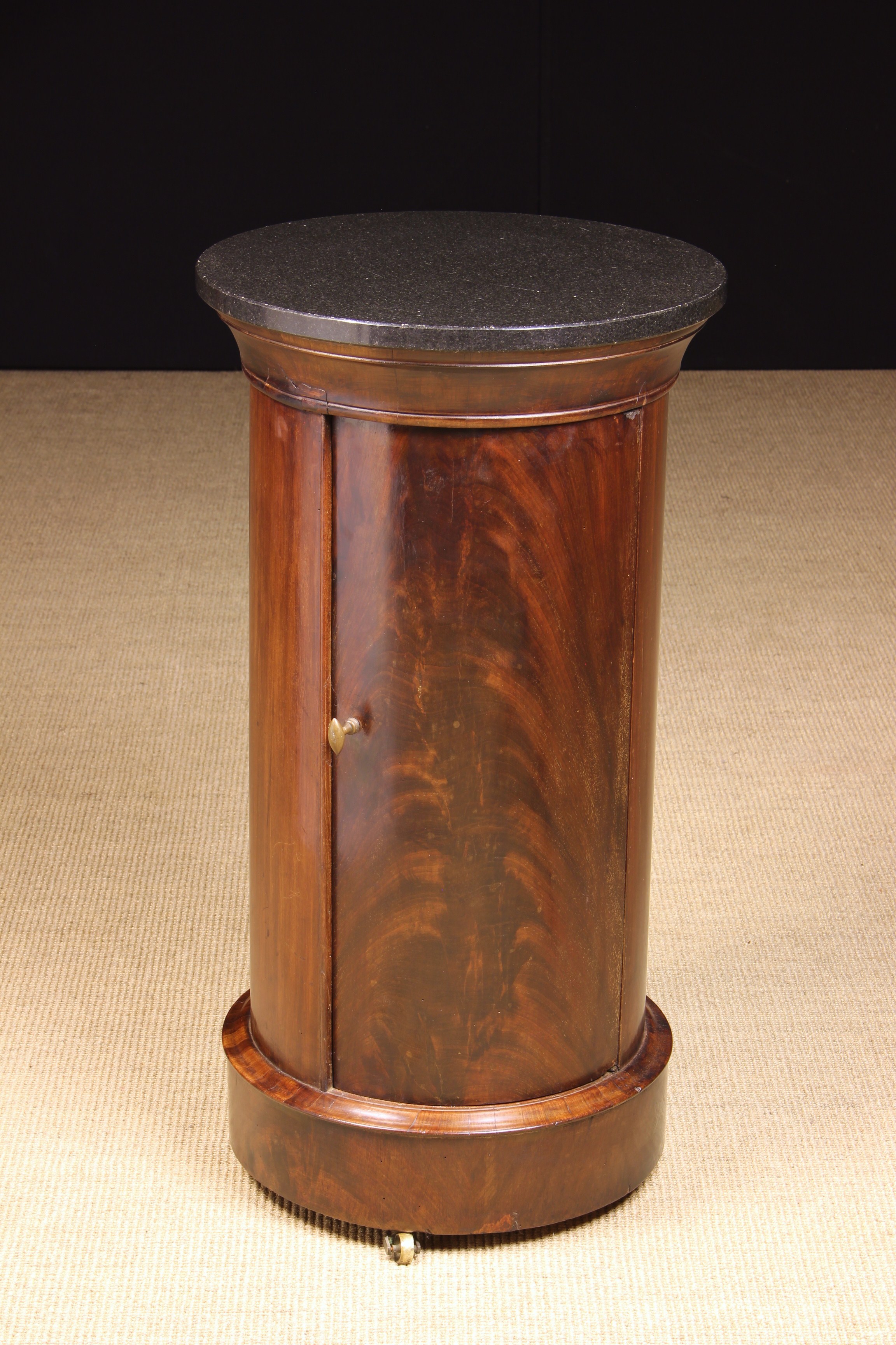 A 19th Century Flame Mahogany Cylindrical Pot Cupboard with plinth base on brass castors and a
