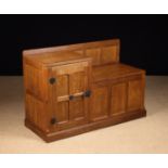 A 1980's Robert Thompson 'Mouseman' Joined Oak Cabinet incorporating a panelled box seat with
