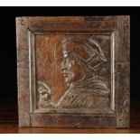 A 16th Century Oak Panel carved with a profile portrait of Cardinal Wolsey and set in a joined oak
