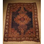 An Old Persian Rug (Worn) woven with a rose ground rosette medallion to the centre,