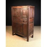 A Westphalian Oak Cupboard having two moulded panel doors to the top above two frieze drawers and a