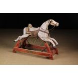 A Vintage Painted Wooden Rocking Horse (A/F) on a wooden stand with iron swing rockers,