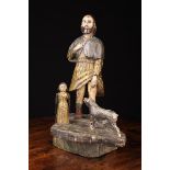 An 18th Century Folk Art Polychromed Wooden Figure Group naively carved with Saint Rochas on a