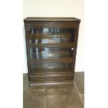 A five piece glazed staking dark oak bookcase with a base drawer, 124cm tall x 87cm x 34cm, some
