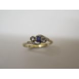 A 9ct three stone (synthetic) cross over ring, size S, approx 2.1 grams, in good condition