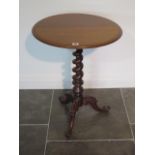A Victorian mahogany tripod table with barley twist stem over cabriole leg base and scroll foot, top