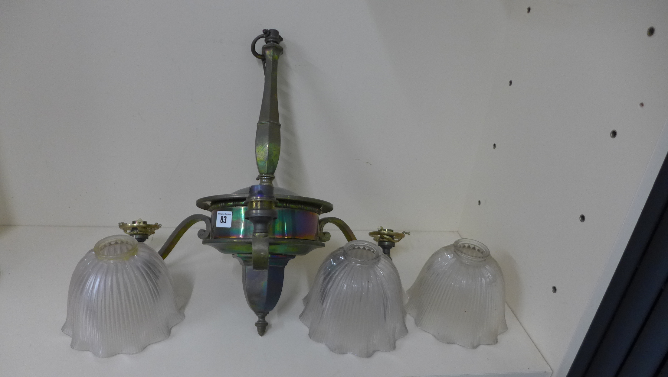 A three branch hanging ceiling light with holophane shades, 74cm tall x 64cm wide, one shade appears