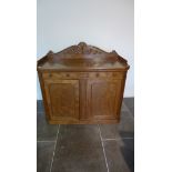 A 19th century mahogany side cupboard / chiffonier with a carved upstand above two drawers and two