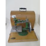 A small sewing machine by Grain, working with case, measures 22cm tall