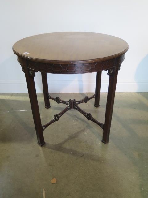 An Edwardian mahogany circular window table with a carved frieze and fretted stretchers, 71cm tall x