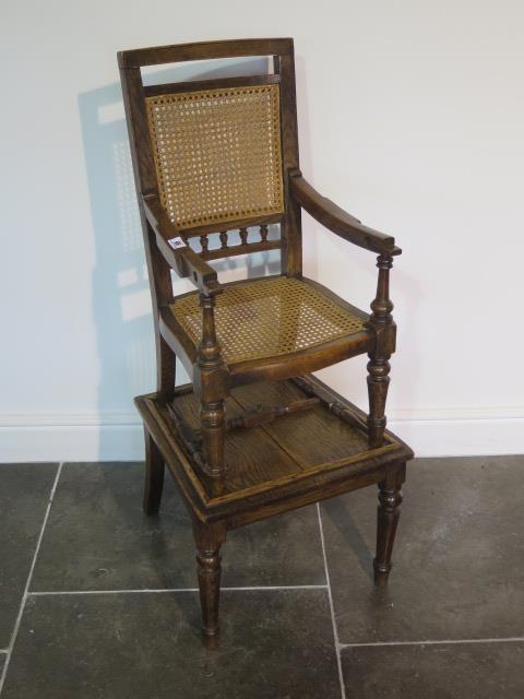 A Victorian oak child's high chair on stand with Bergere cane seat and back, chair detaches from