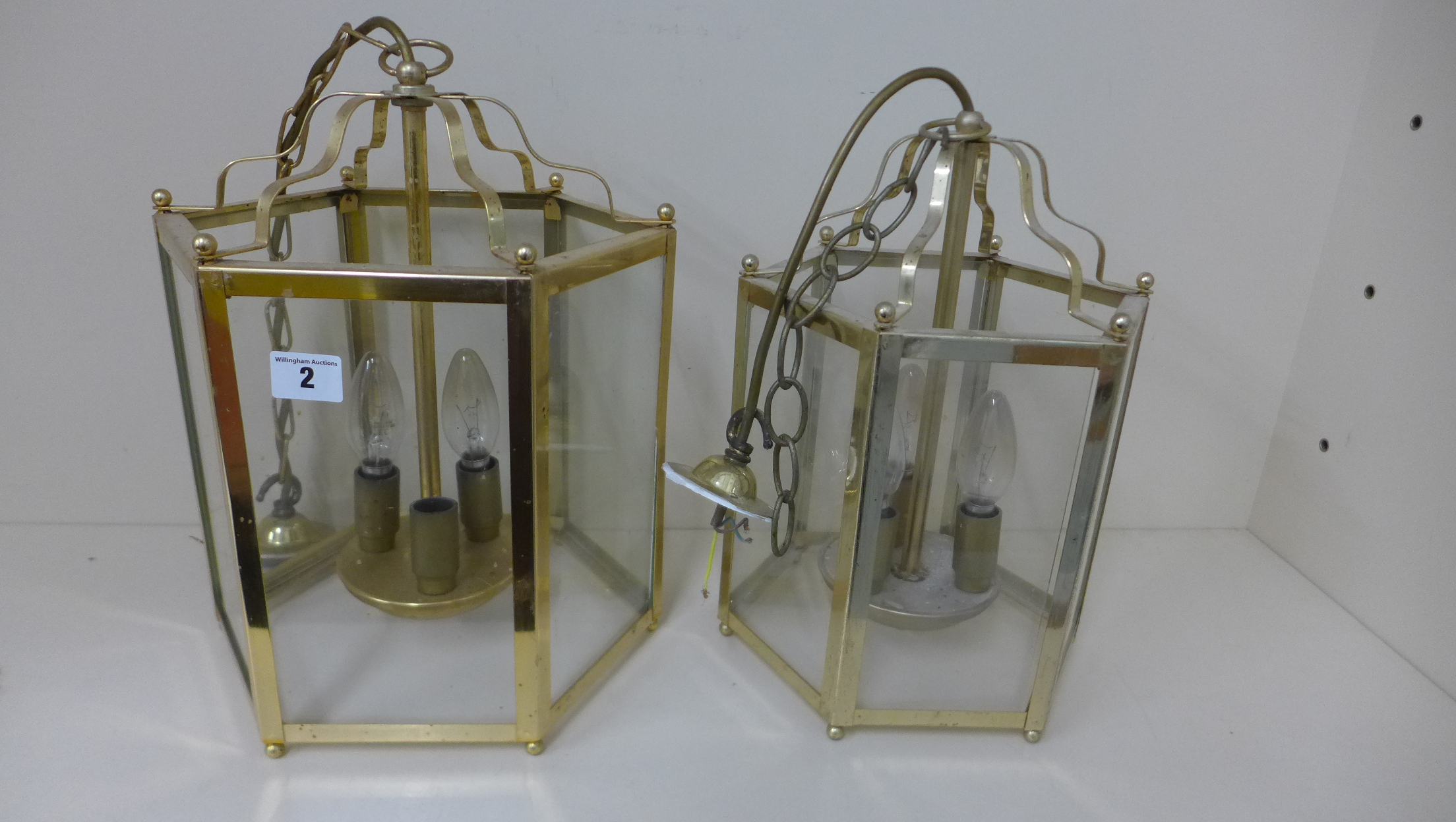A brass hexagonal hall lantern, 37cm x 25cm, and a similar smaller silvered lantern