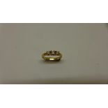 A yellow gold three stone diamond ring, centre stone approx 0.20ct, size Q, not hallmarked, tests to