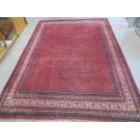 A hand knotted woollen rug with a red field - generally good, some small fading, no holes - 320cm
