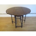 A small oak gateleg table on finely turned supports - Height 66cm x 84cm x 72cm
