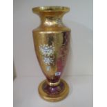 A large floral and gilt decorated cranberry colour glass vase - Height 50cm