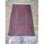 A hand knotted woollen Afghanistan rug with a rust red field - some wear mainly to edges - 155cm x