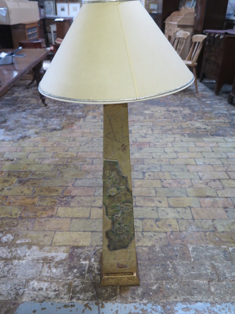 A beautiful gold covered obelisk shaped lampshade with defined intricate pattern and floral design