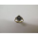 A 9ct yellow gold sapphire and diamond ring - the centre set with four square cut stones - ring size