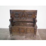 A very good carved oak monks bench, with hinged seat and panelled storage below, heavily carved