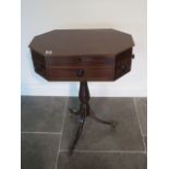 An octagonal mahogany work table with two active drawers and a rising top on a turned column and