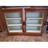 A pair of walnut open bookcases with painted interior and adjustable shelves made by a local