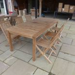 A teak garden table and six folding chairs - in good condition - 220cm x 100cm
