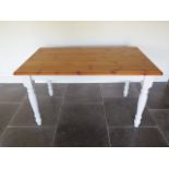 A pine kitchen table with painted turned leg base - height 76cm x 137cm x 81cm
