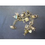 A 9ct gold charm bracelet - length 16cm with 17 charms - approx weight 61 grams