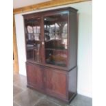 A good Georgian mahogany bookcase on cupboard of small proportions with a two door glazed top over a