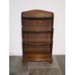 A 20th century solid mahogany three shelf waterfall bow front bookcase with drawer below standing on