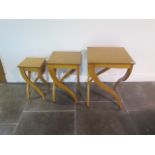 A nest of three blonde wood side tables with shaped legs, top loose to one, legs need some attention