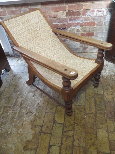 An early 20th century hardwood colonial planters chair, 83cm tall x 117cm deep, without extensions