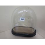 A glass dome, 21cm high x 24cm wide, with base, in good condition