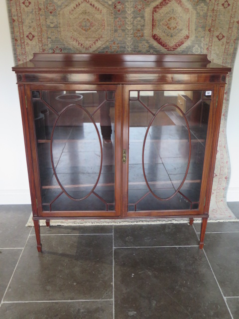 An Edwardian mahogany two door astragel glazed display cabinet with three adjustable shelves, in