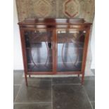 An Edwardian mahogany two door astragel glazed display cabinet with three adjustable shelves, in