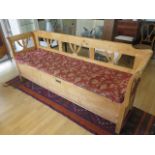 A 19th century continental stripped pine hall bench with lift upseat and cushion, 90cm tall x