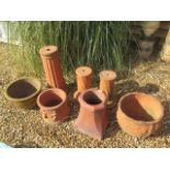 A terracotta plant stand 61cm tall, a pair of smaller stands, two terracotta planters, a small