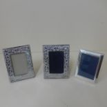 A pair of small silver frame photograph frames and another